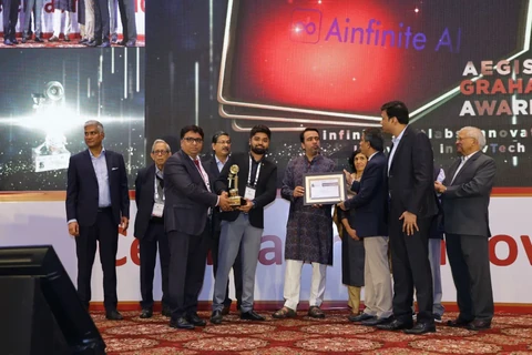 A group on an awards stage holding a trophy and a framed certificate.